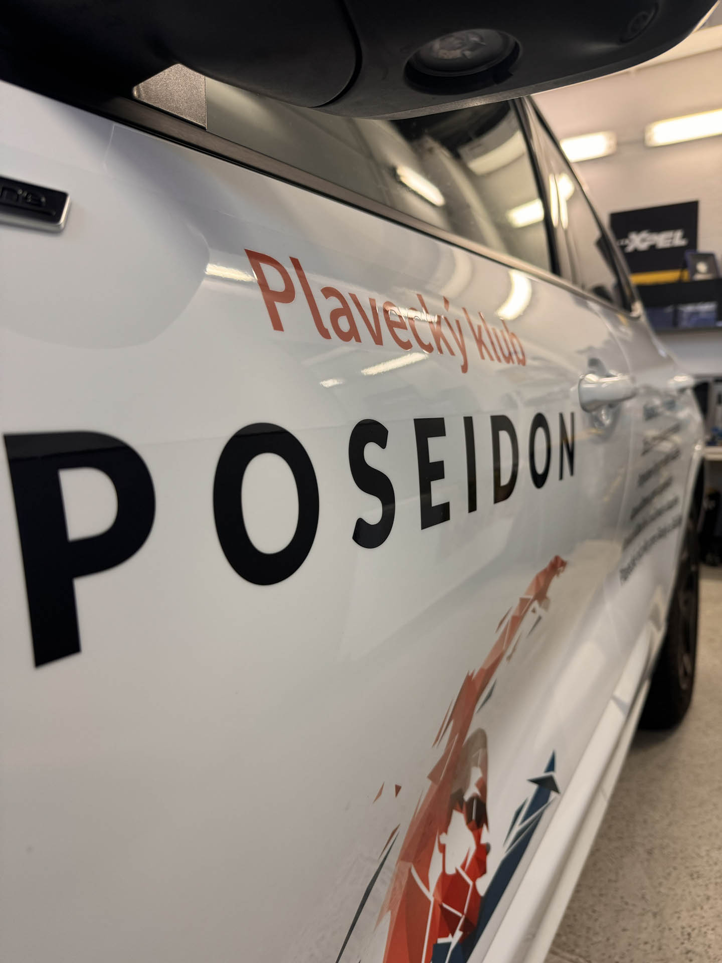 Detail nápisu Poseidon na bočnej strane auta po polepe v dielni v Bratislave