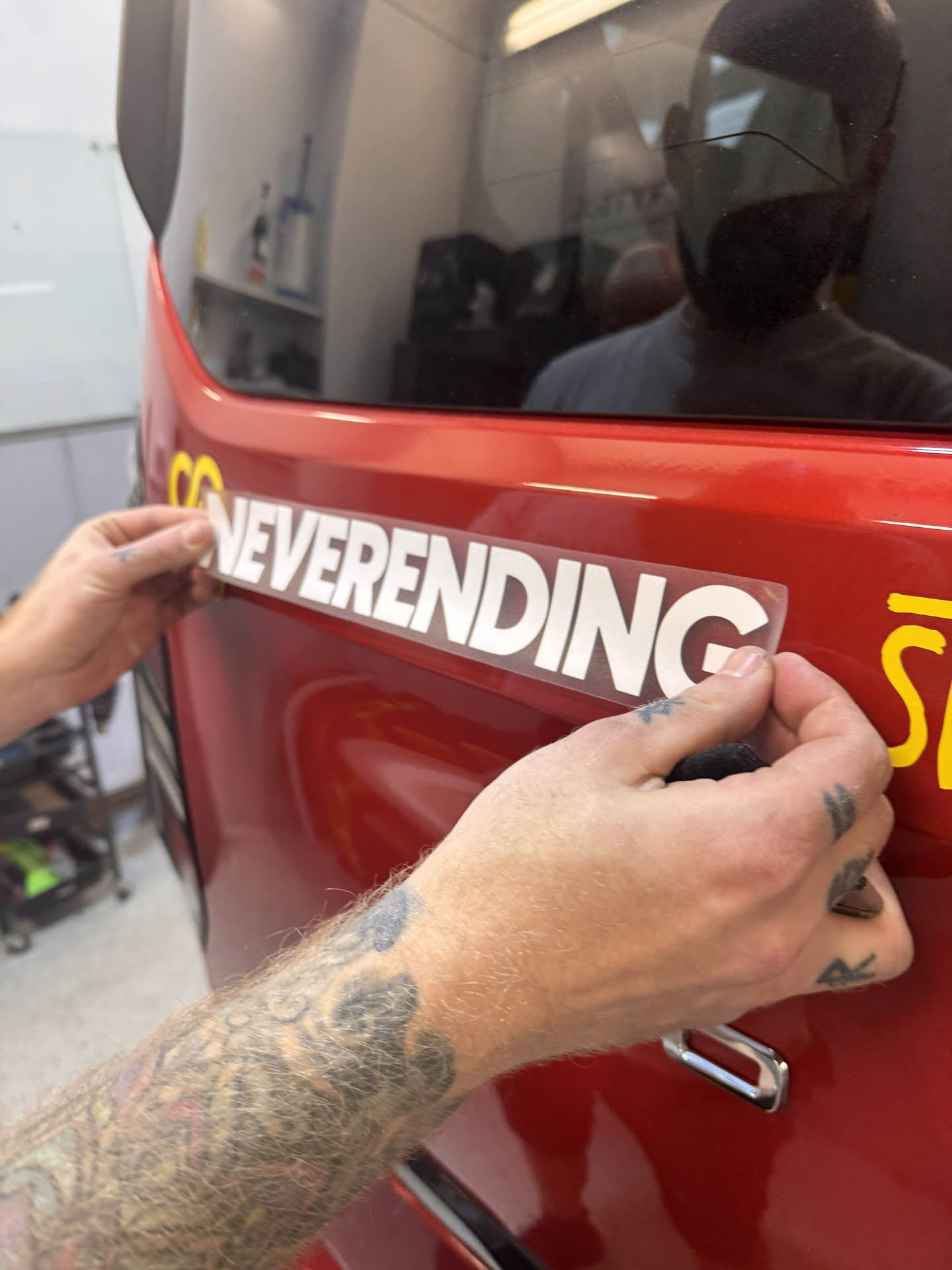 Biely nápis Neverending story a žlté logo na boku dodávky, reklamné polepy na auto